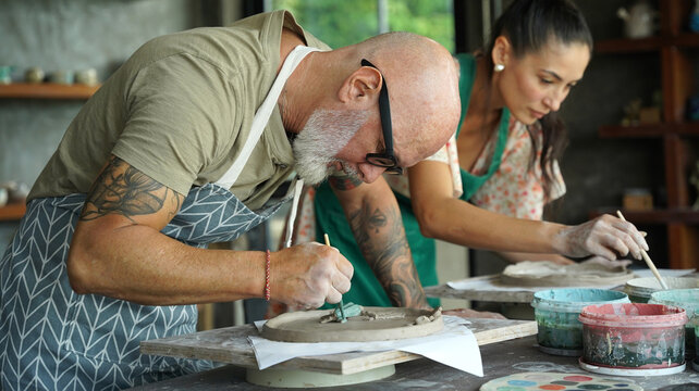 A happy couple makes ceramic plates in a workshop