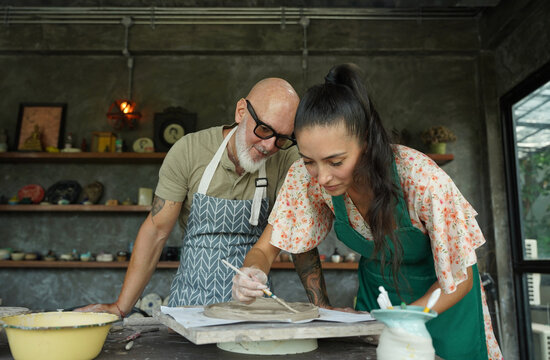A happy couple makes ceramic plates in a workshop