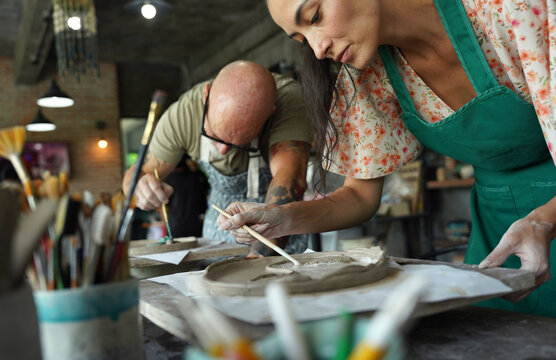 A happy couple makes ceramic plates in a workshop