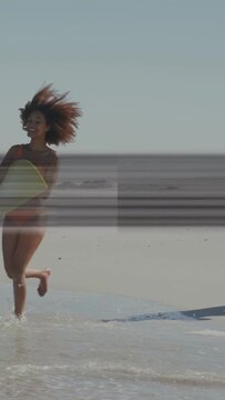 Vertical video: Woman entering with board then man running to surf; animated bands crossing above