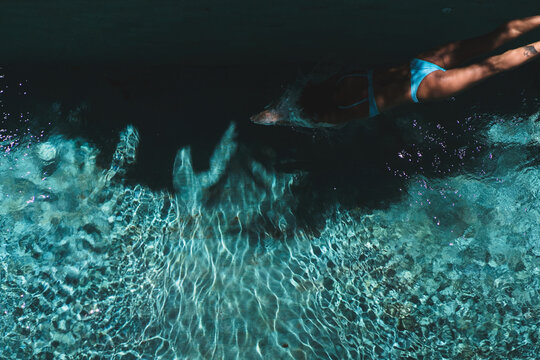 Top view of woman diving into dark villa pool, Uluwatu, Bali