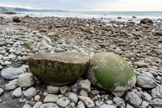 Two halves of large round rock on New Zealand coast