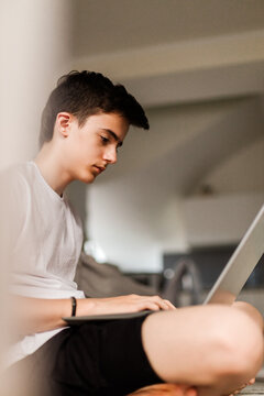 Concentrated young male student working on laptop