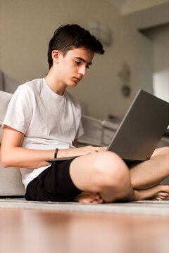Serious adolescent boy browsing on computer