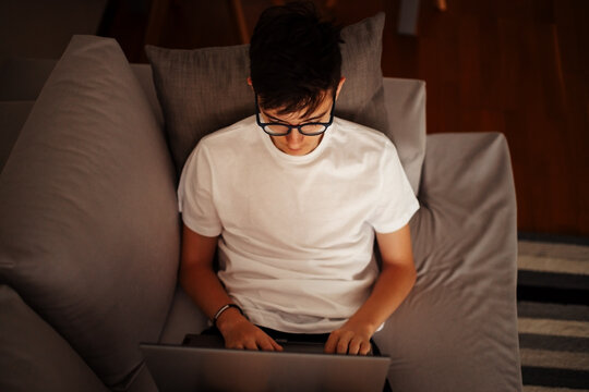 Focused young person working late on laptop computer