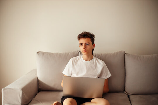 Serious teenage student studying online using computer