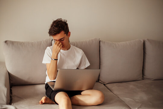 Tured young person working on laptop