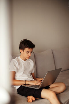 Concentrated teenager working on computer from home