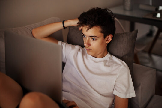 Focused teenager working on laptop
