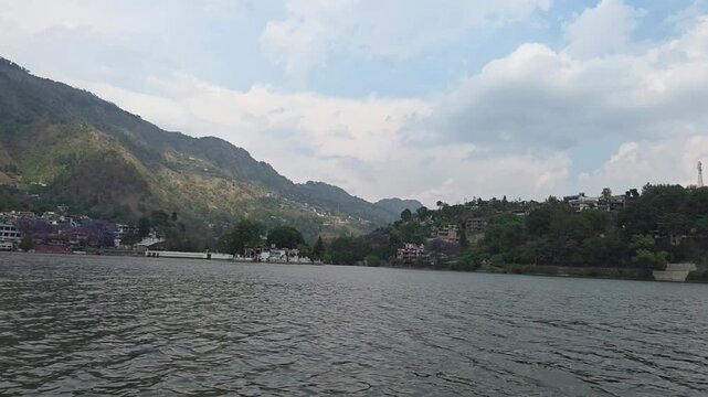 Wide landscape of Bhimtal Lake with surrounding hills and calm water surface.