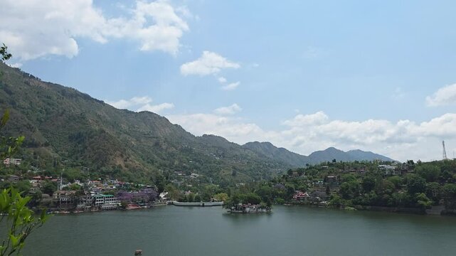 Bright blue sky over Bhimtal Lake with hills and calm water below