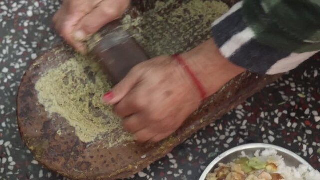 Raw 4K footage of masala grinding on sil batta stone, showing traditional Indian spice preparation, authentic cooking method, and simple rural kitchen lifestyle.