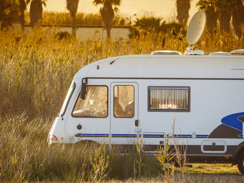 Caravan with satellite dish on roof camping on spanish nature