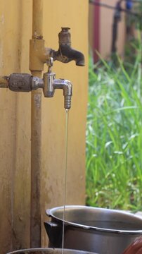 Raw 4K footage of water filling a bucket from a pipe, showing daily water usage, simple rural lifestyle, and basic resource collection in an Indian village.