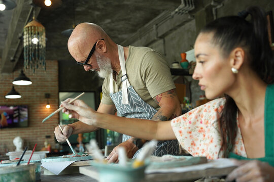 A happy couple makes ceramic plates in a workshop