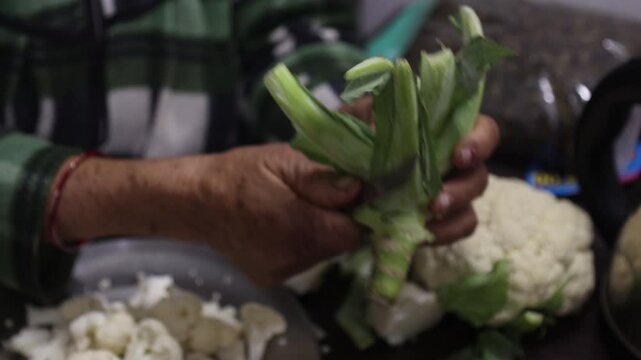 Raw 4K footage of hands peeling cauliflower in a kitchen, showing food preparation, fresh vegetables, and simple rural lifestyle in an Indian household.