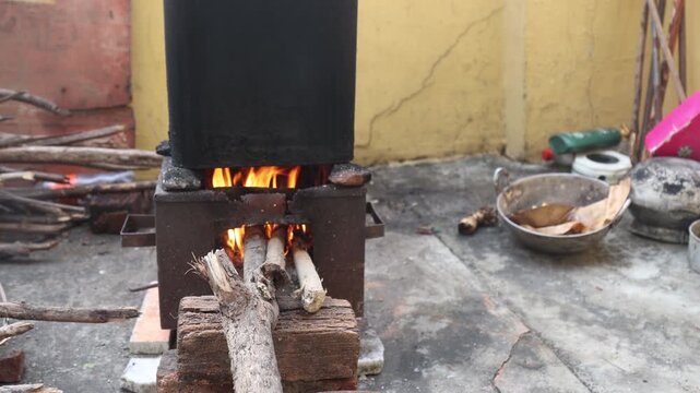 Raw 4K footage of water being heated on a wood fire for bathing, showing traditional method, simple living, and rural household routine in India.