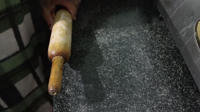 Raw 4K footage of chapati being prepared on a kitchen floor, showing traditional cooking style, simple living, and rural household food preparation in India.