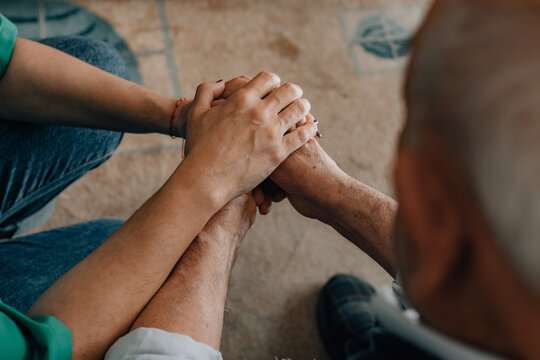elderly couple tenderly holding hands, a gesture of emotional support, love, connection, and care between older people indoors