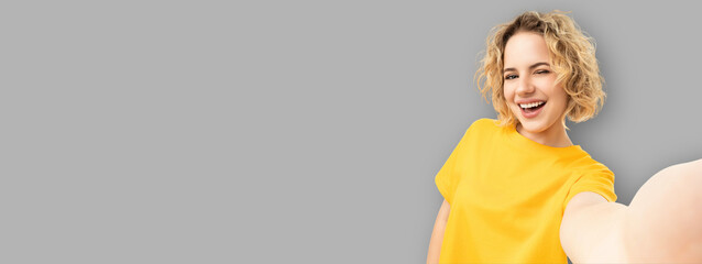 Woman smiles while posing with a gadget in a creative space