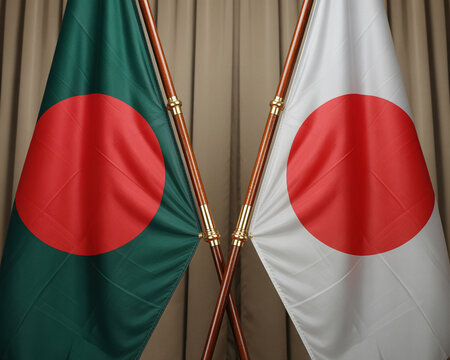 Crossed flags of Bangladesh and Japan displayed on wooden poles
