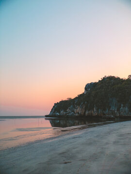 Gentle evening light bathes peaceful coast beneath pastel skies