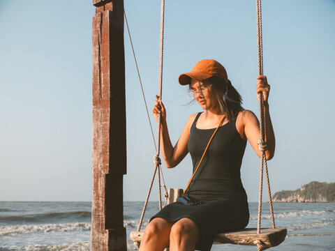 Female enjoying bright sunlight and joyful moments on swing
