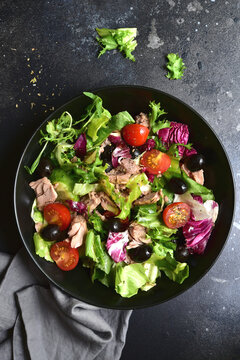 Tuna salad with olives and tomatoes. Top view with copy space.