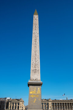 The ancient Egyptian Obelisk stands tall in the center of Place de la Concorde in Paris under a clear blue sky.