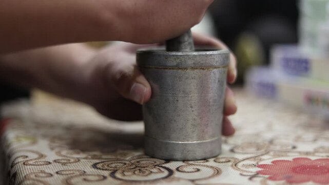 Raw 4K footage of masala grinding in a brass Khal Batta also known as Imam Dasta, showing traditional Indian spice preparation and authentic rural kitchen lifestyle.