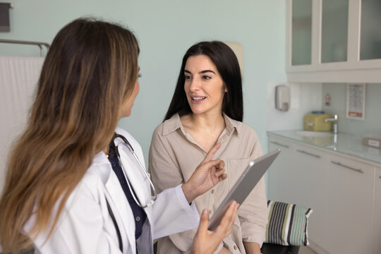 Doctor showing medical information, scan results on tablet to patient, explaining recent imaging or screening outcomes, clarifying condition, discuss treatment options, further therapy or procedures