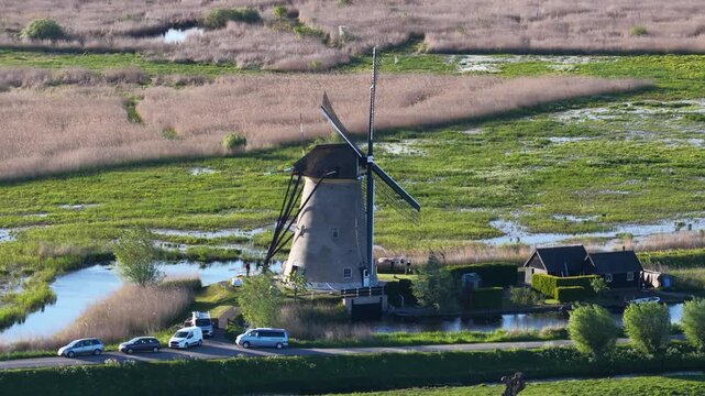 Traditional dutch windmill spinning in rural netherlands landscape