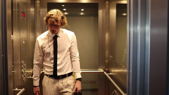 Tired office worker stands in the elevator with a briefcase and earphones capturing fatigue mental overload low energy and the pressure of a demanding work routine