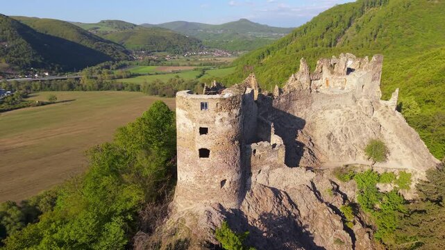 Stunning aerial footage showcasing the ancient ruins of Sasovsky Castle, majestically perched on a rocky cliff overlooking a lush valley