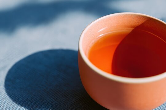 テクスチャーのある表面に日光浴をしたお茶のカップ