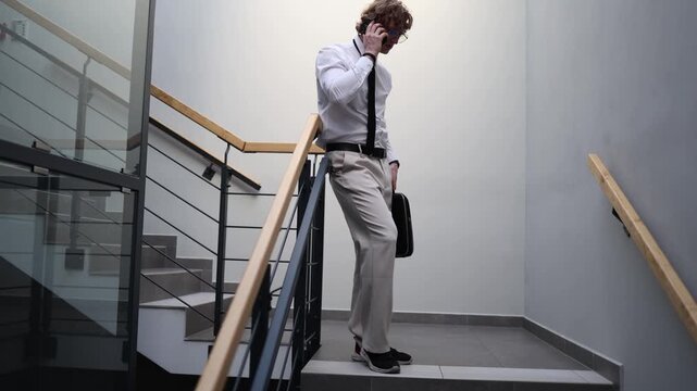 Freelancer pauses on the stairway checking a phone in a quiet moment of overload showing work fatigue digital pressure mental exhaustion and a demanding daily routine