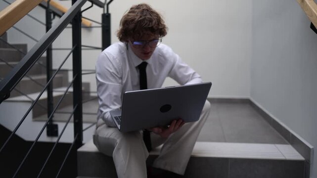 Deep in thought professional pausing on office stairs holding laptop reflecting on decisions quiet contemplation moment mental clarity problem evaluation focused introspection