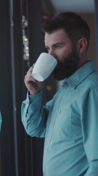 Gentle morning scene at window, Casual morning routine captured with man sipping coffee near bright window