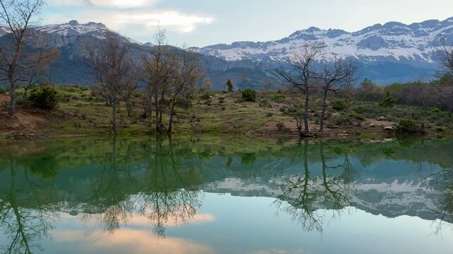 Serene mountain lake with perfect reflection and an old wooden boat