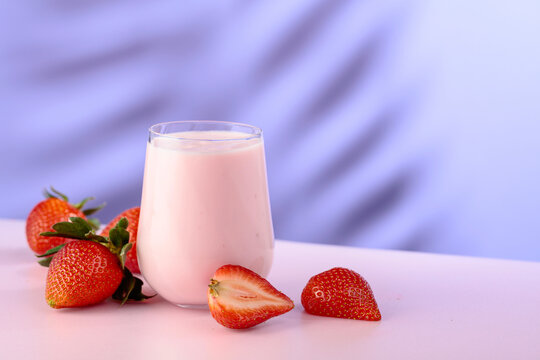 Strawberry yogurt and fresh berries on a colorful background.