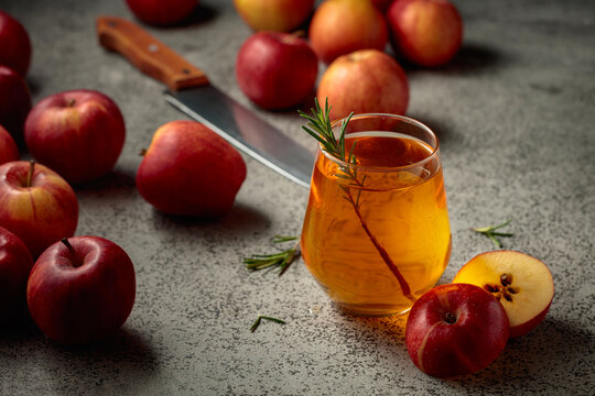 Apple juice and fresh apples on a kitchen table.