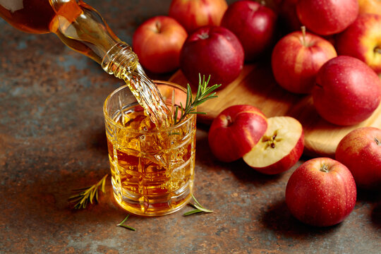 Apple kombucha is poured from a bottle into a glass.