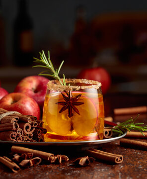 Apple cider with apple slices, anise, and a rosemary branch.