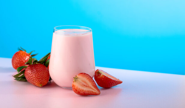 Strawberry yogurt and fresh berries on a colorful background.
