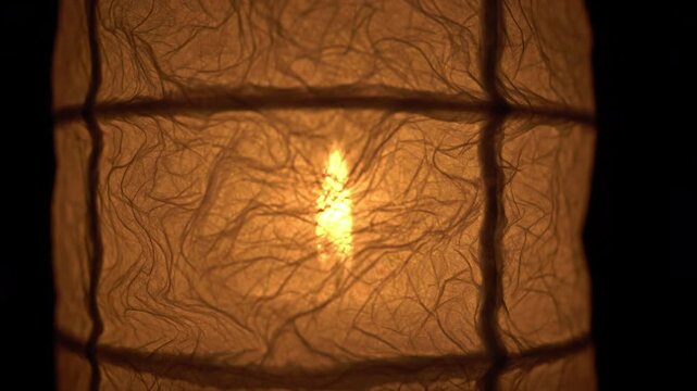 Closeup of a textured paper lantern with a warm glowing light source inside, evoking a cozy atmosphere