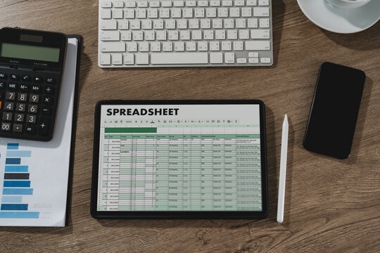 ablet displaying spreadsheet data on desk with calculator, keyboard, smartphone, and chart document, representing financial analysis workflow, accounting calculation, budgeting process, and business d