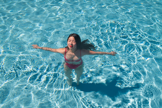 art p[ortrait of young asian woman swimming in the pool