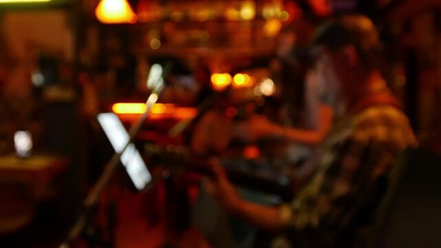 Blurred defocused live music jazz band performance inside cozy vintage bar with warm golden red bokeh ambiance nightlife