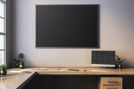 Clean office desk with large blank blackboard on wall in soft light creating modern workspace mockup scene for design and branding. 3D Rendering