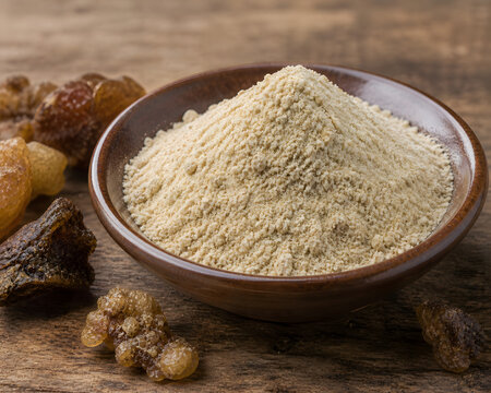 Asafoetida Hing Powder in Wooden Bowl with Dried Resin Pieces on Rustic Wooden Table &ndash; Ayurvedic Indian Spice Concept